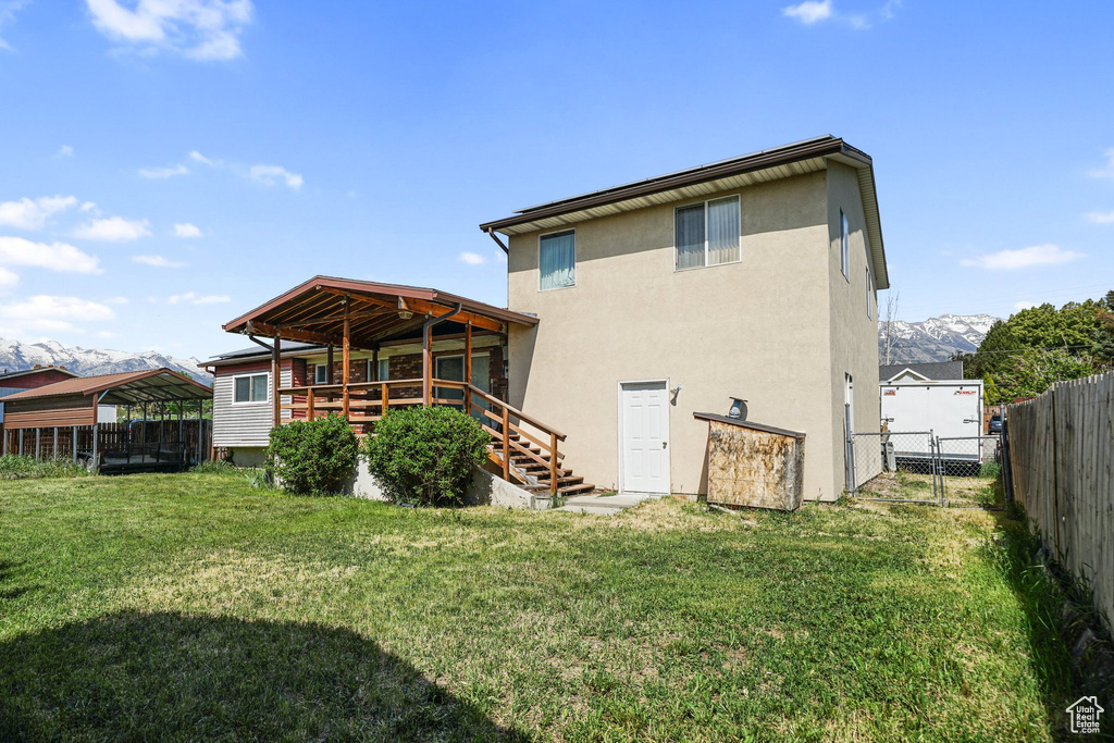 Back of property featuring stucco siding, stairs, and a gate