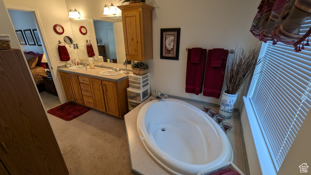 Bathroom featuring ensuite bath, a bath, and double vanity