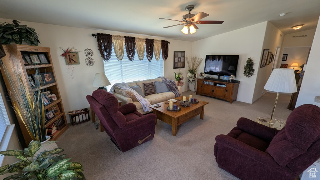 Living room with light colored carpet, a ceiling fan, and lofted ceiling