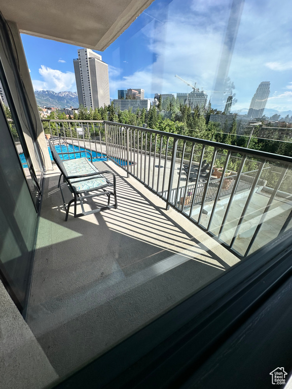 Balcony with a view of city and view of pool area