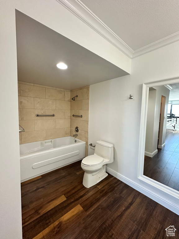 Full bath featuring wood finished floors, ornamental molding, and tub / shower combination