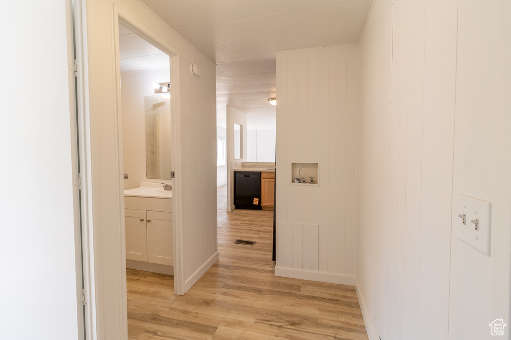 Hallway featuring light wood-style flooring and a sink