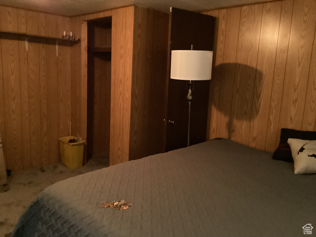 Bedroom featuring wood walls and carpet floors