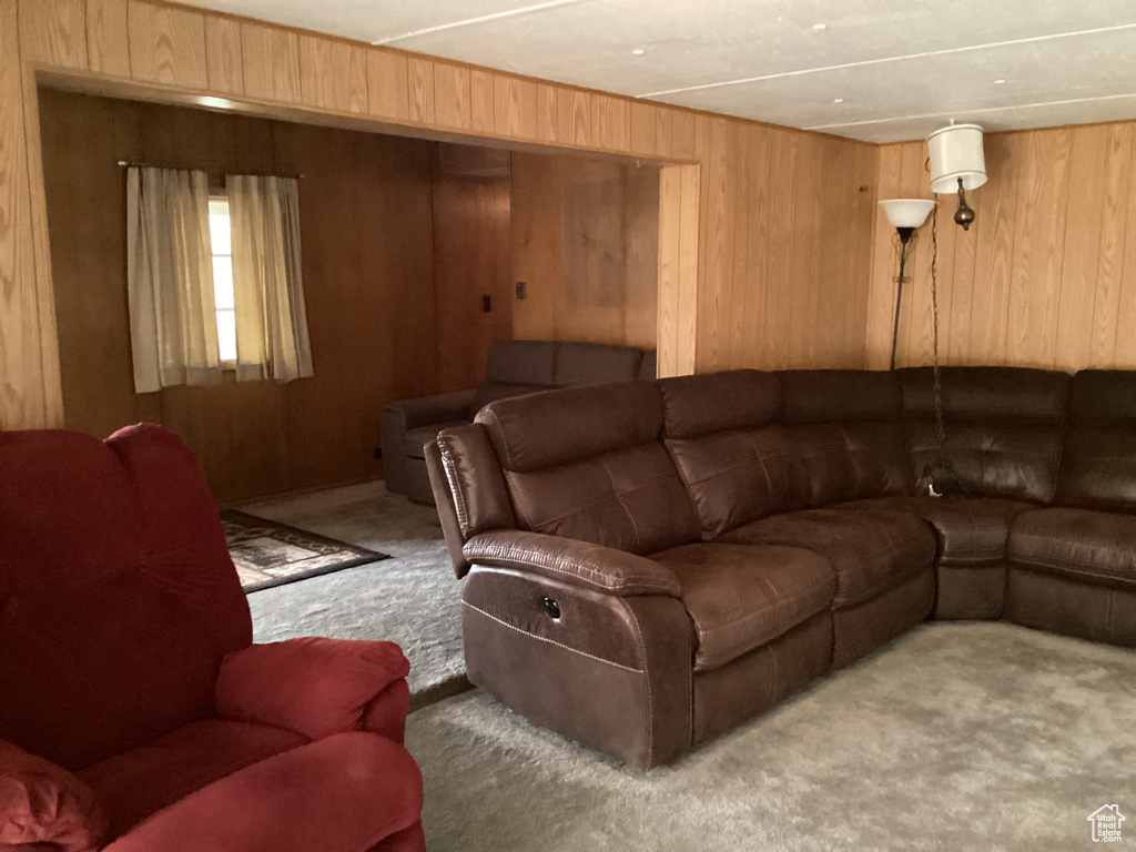 Living room with carpet floors and wood walls