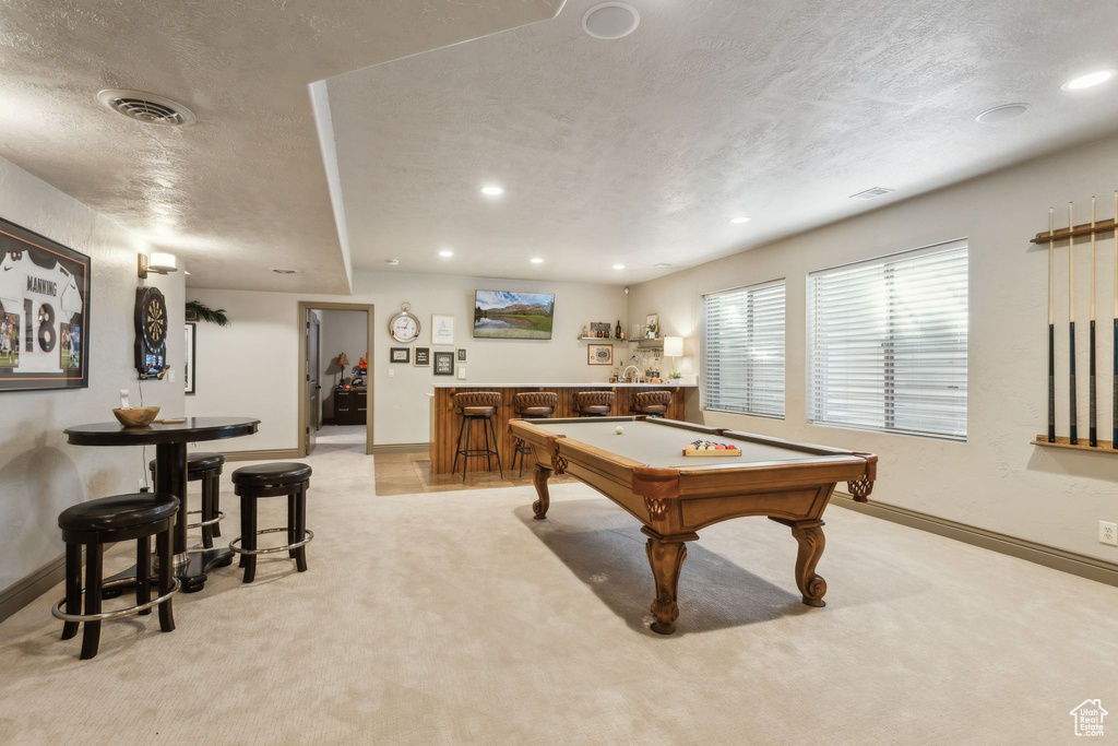 Rec room with wet bar, light carpet, a textured ceiling, baseboards, and billiards table