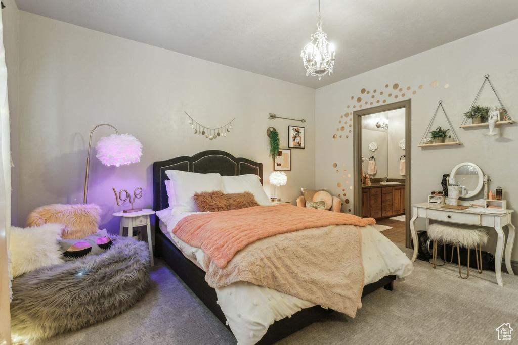 Bedroom with a chandelier, carpet floors, ensuite bathroom, and a sink