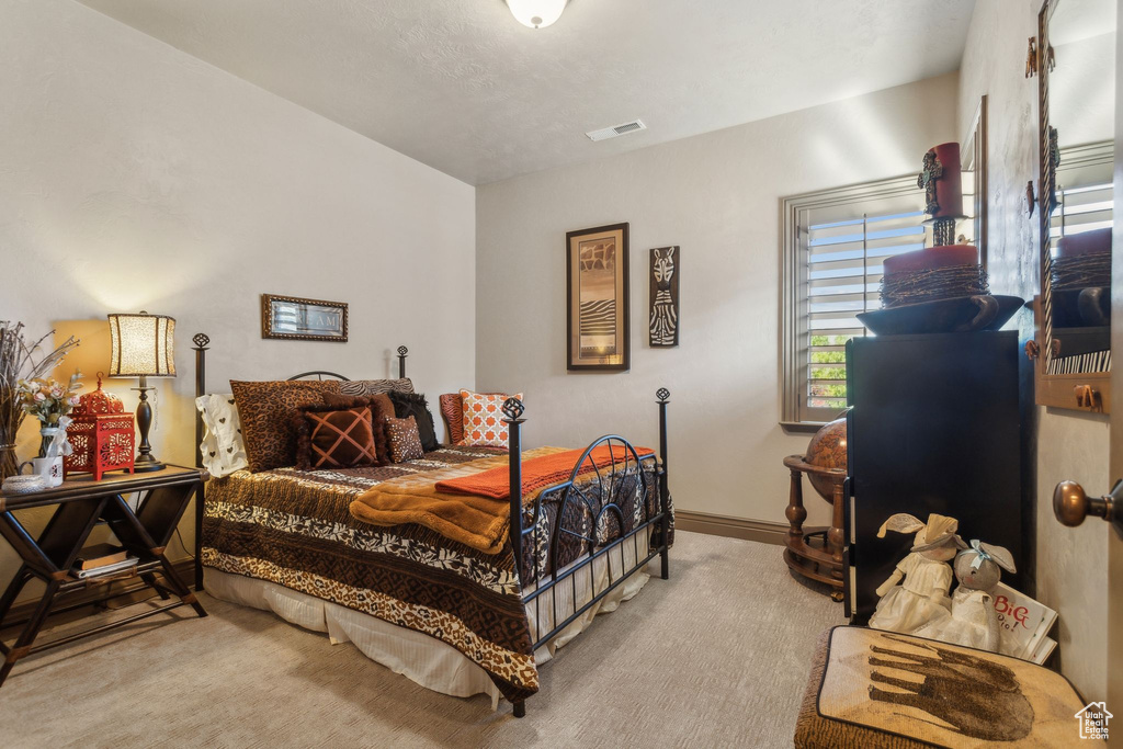 Bedroom featuring light carpet and baseboards