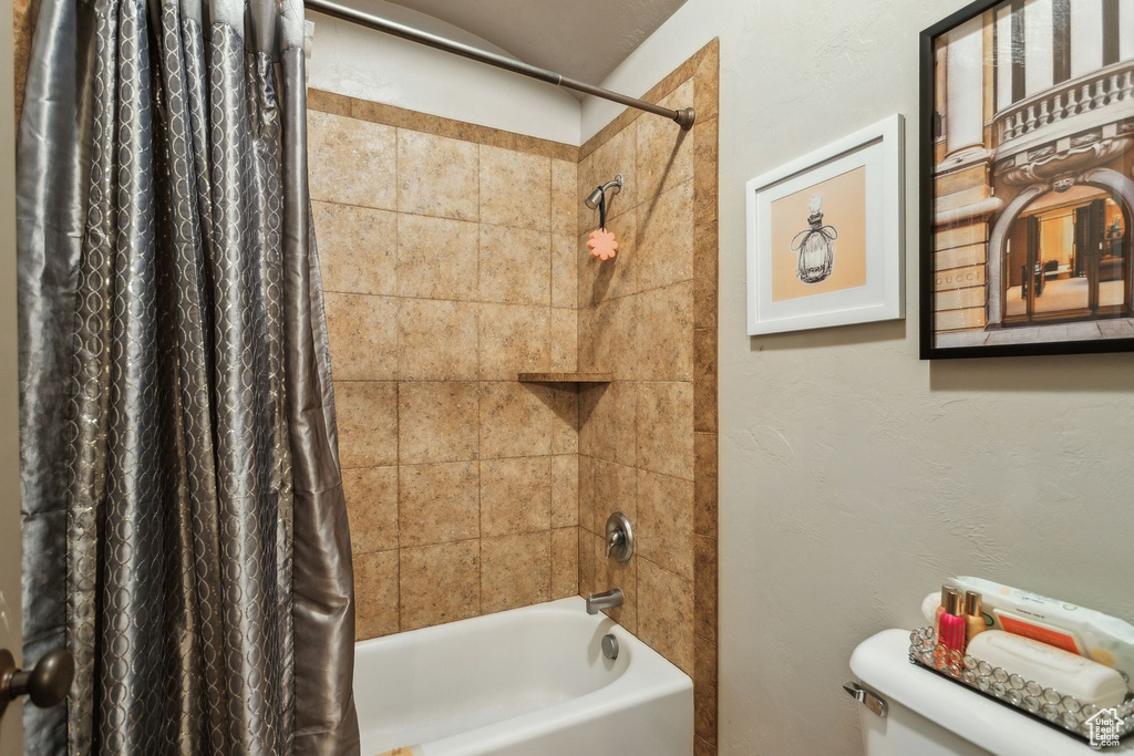 Full bath featuring shower / tub combo with curtain and toilet