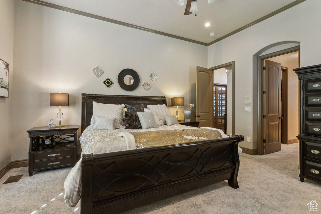 Bedroom with light carpet, ornamental molding, baseboards, and ceiling fan