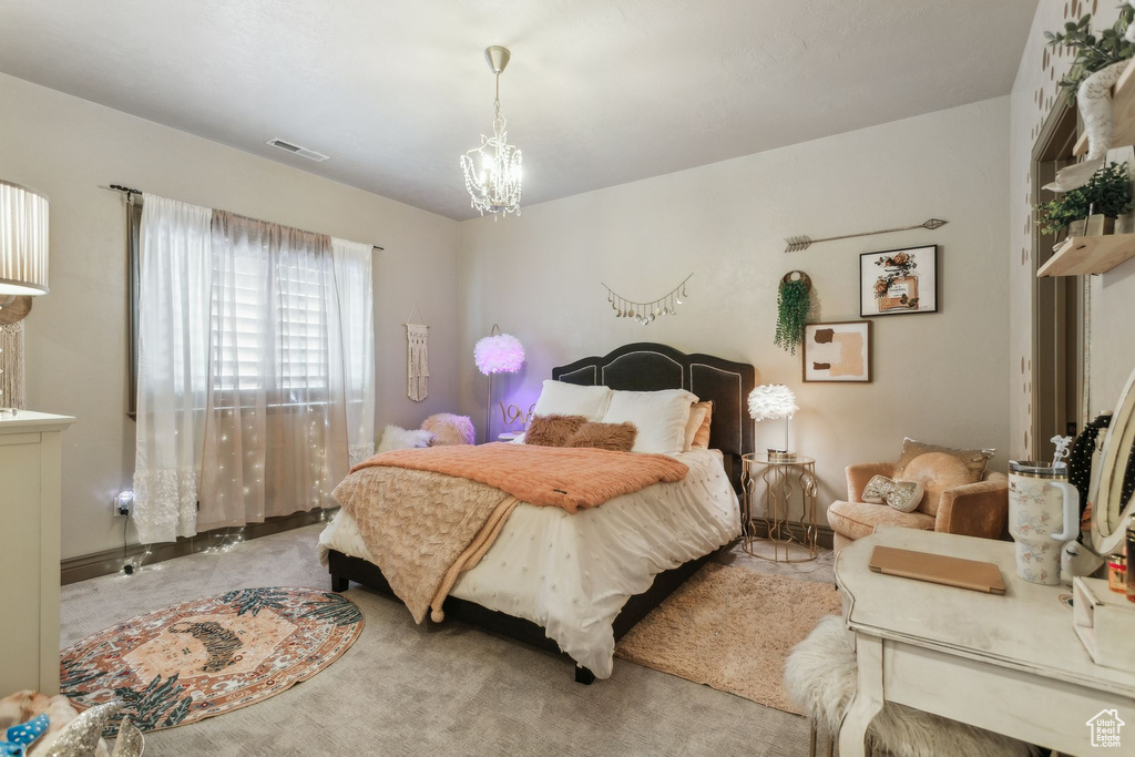 Bedroom with a chandelier and carpet floors