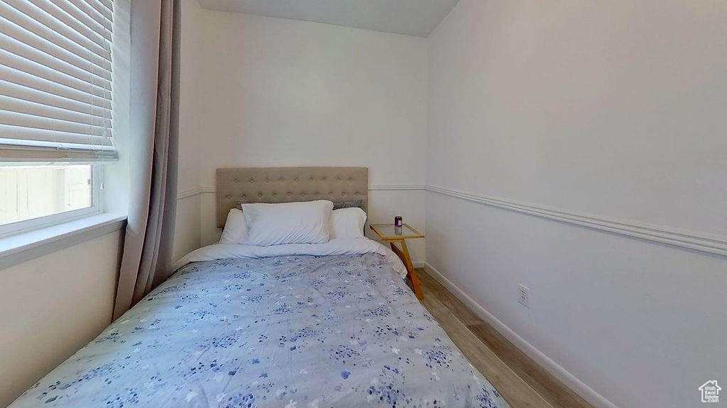 Bedroom featuring wood finished floors and baseboards