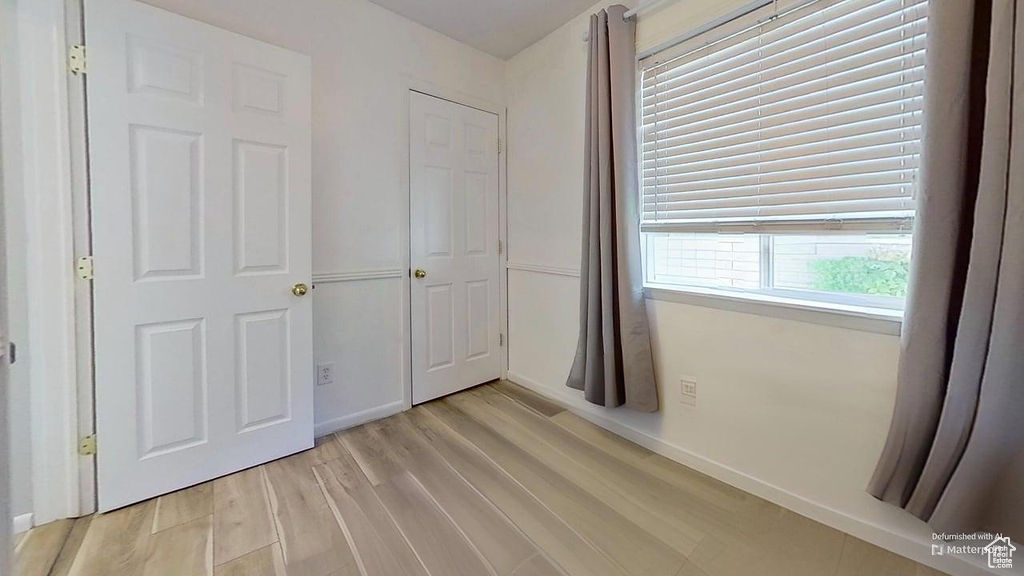 Unfurnished bedroom featuring light wood-type flooring and baseboards