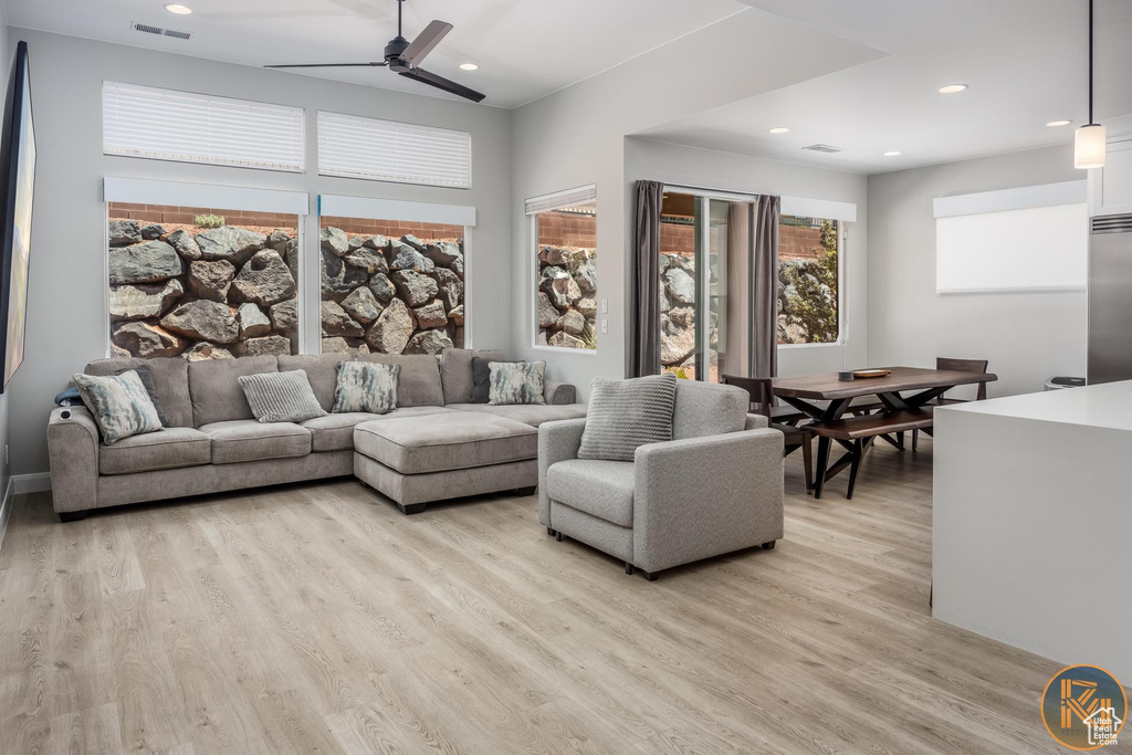Living room with light wood finished floors, ceiling fan, and recessed lighting