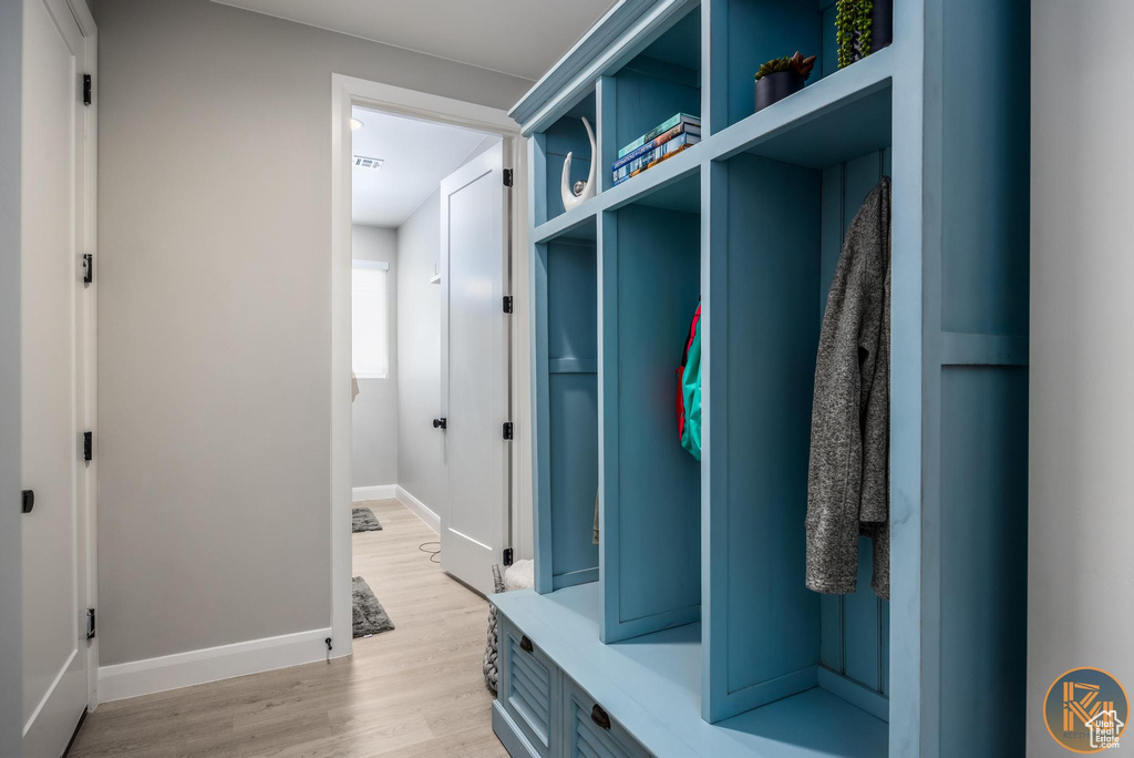 Mudroom with light wood-style floors and baseboards