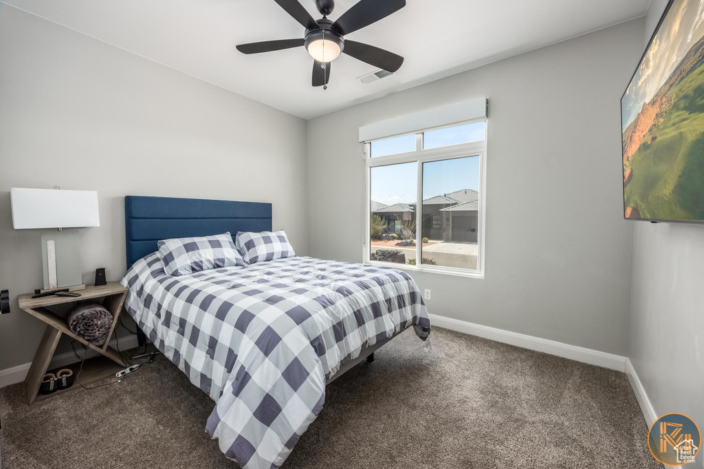 Carpeted bedroom featuring baseboards and a ceiling fan