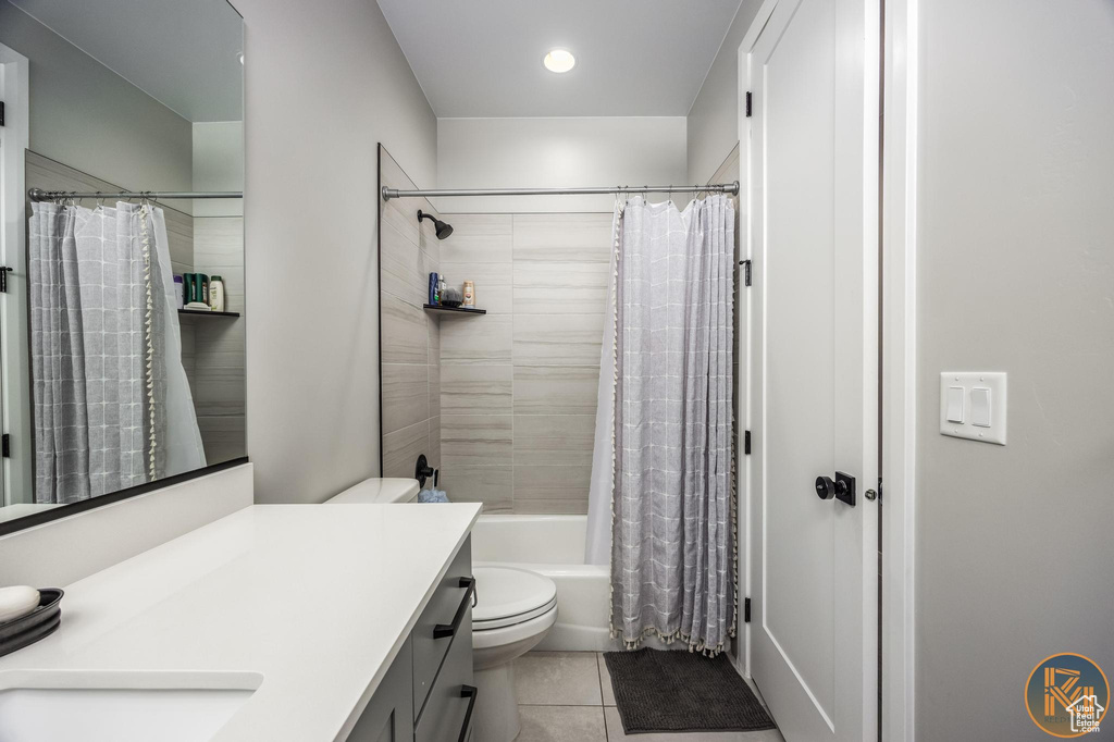 Bathroom featuring vanity, tile patterned floors, shower / bathtub combination with curtain, and toilet