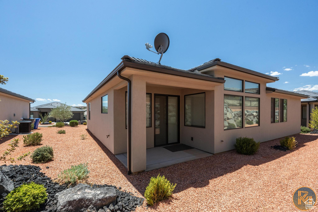 Rear view of property with a patio, stucco siding, and central AC