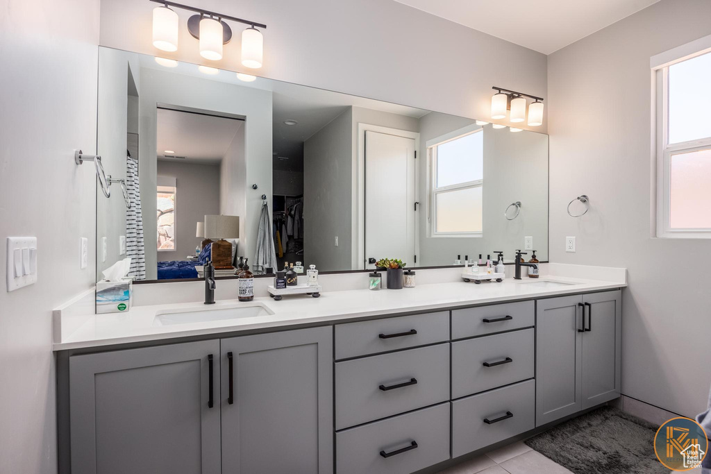 Full bathroom featuring double vanity and tile patterned flooring