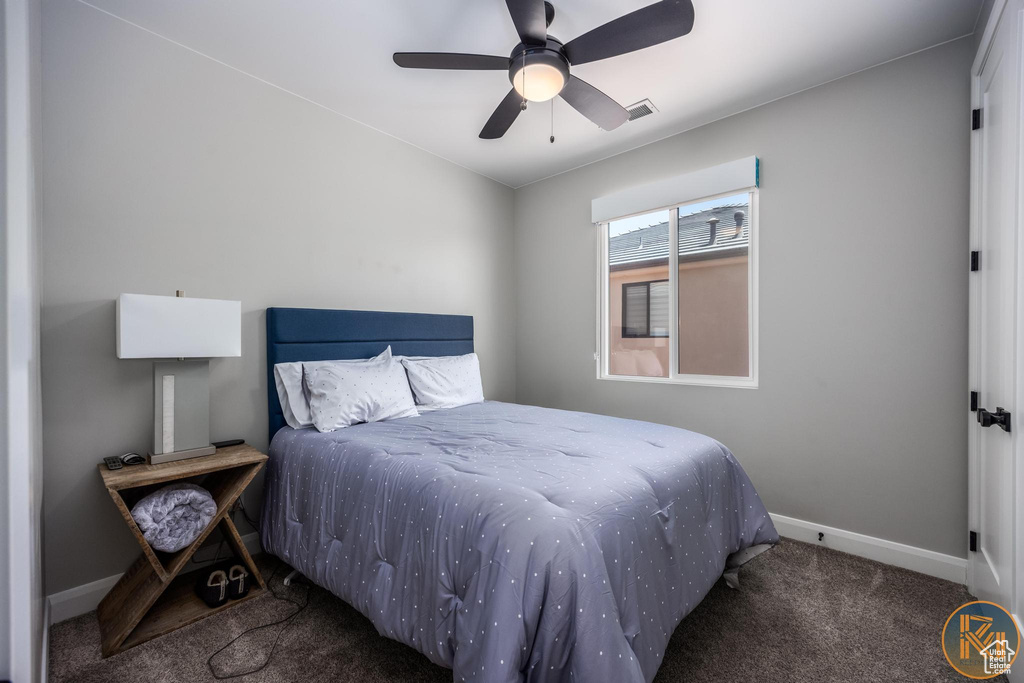 Carpeted bedroom featuring baseboards and ceiling fan