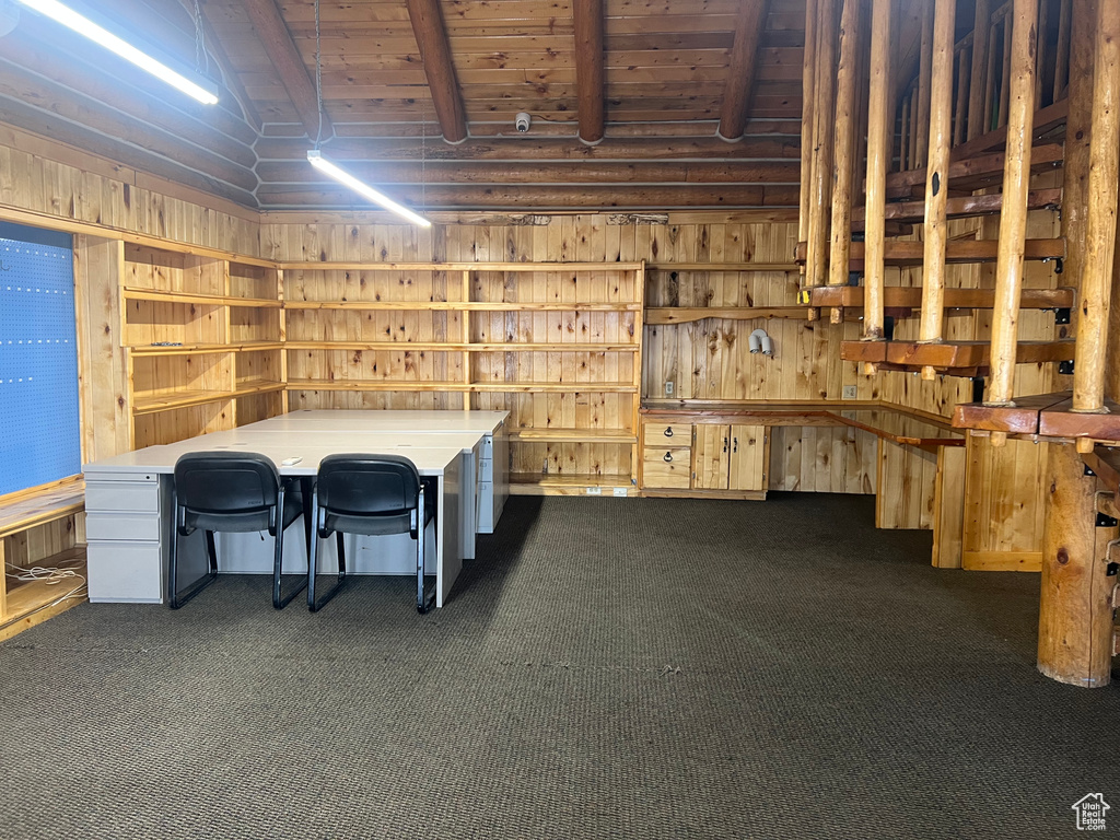 Misc room featuring wooden ceiling, dark colored carpet, and wood walls