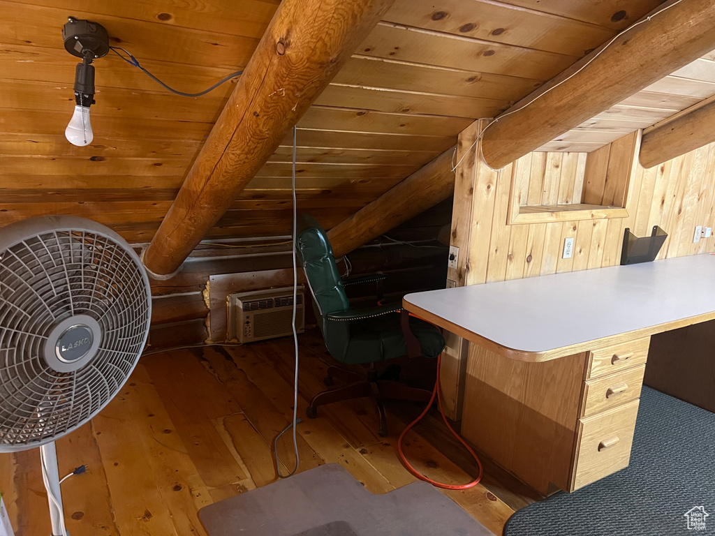 Office featuring hardwood / wood-style floors, wood ceiling with exposed beams, and log walls