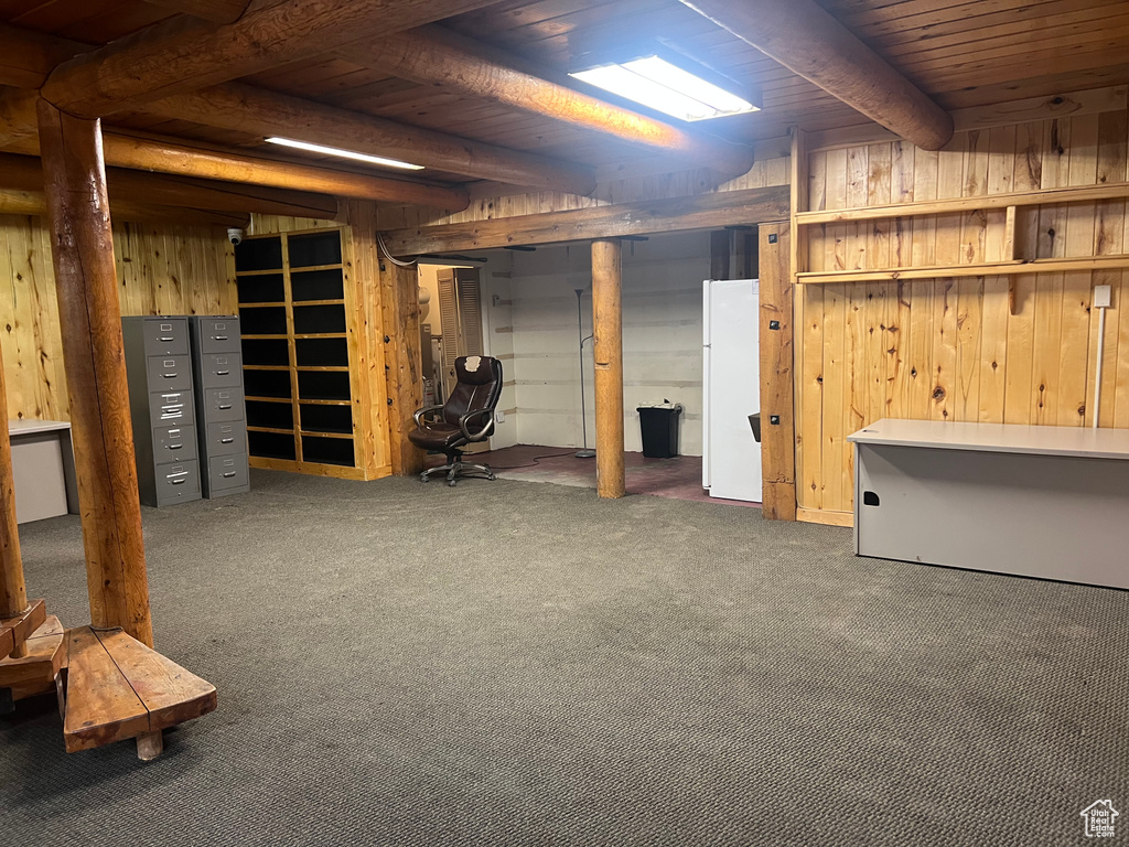 Finished below grade area with wooden walls, wooden ceiling, carpet flooring, and freestanding refrigerator