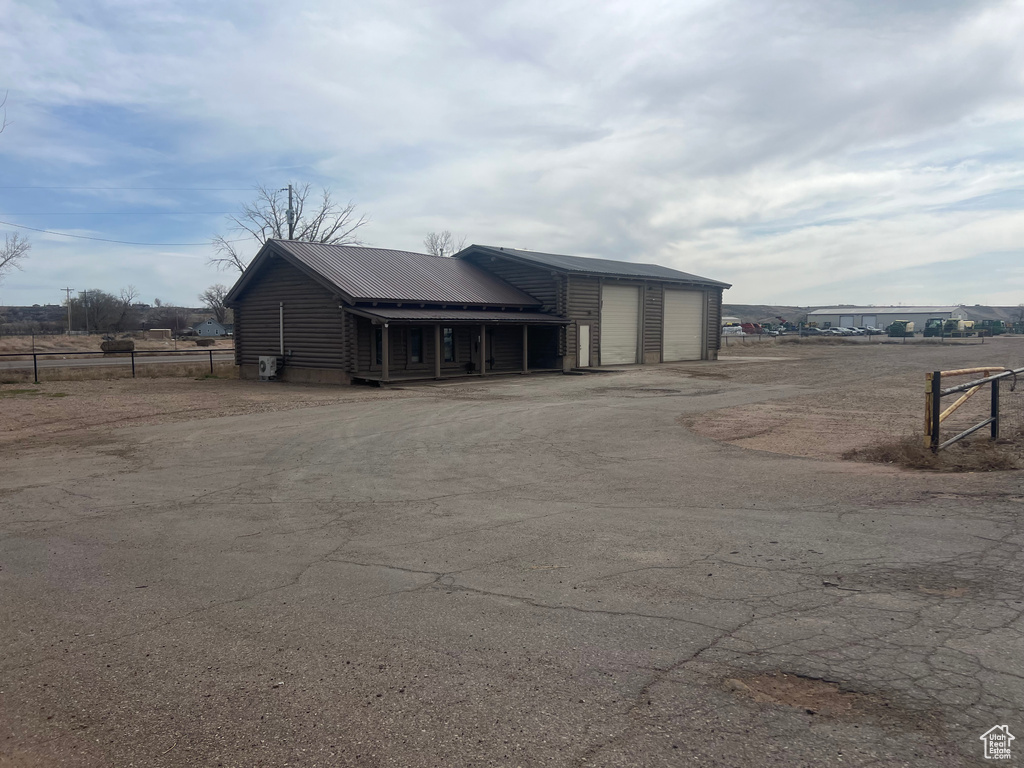 View of outdoor structure with dirt driveway
