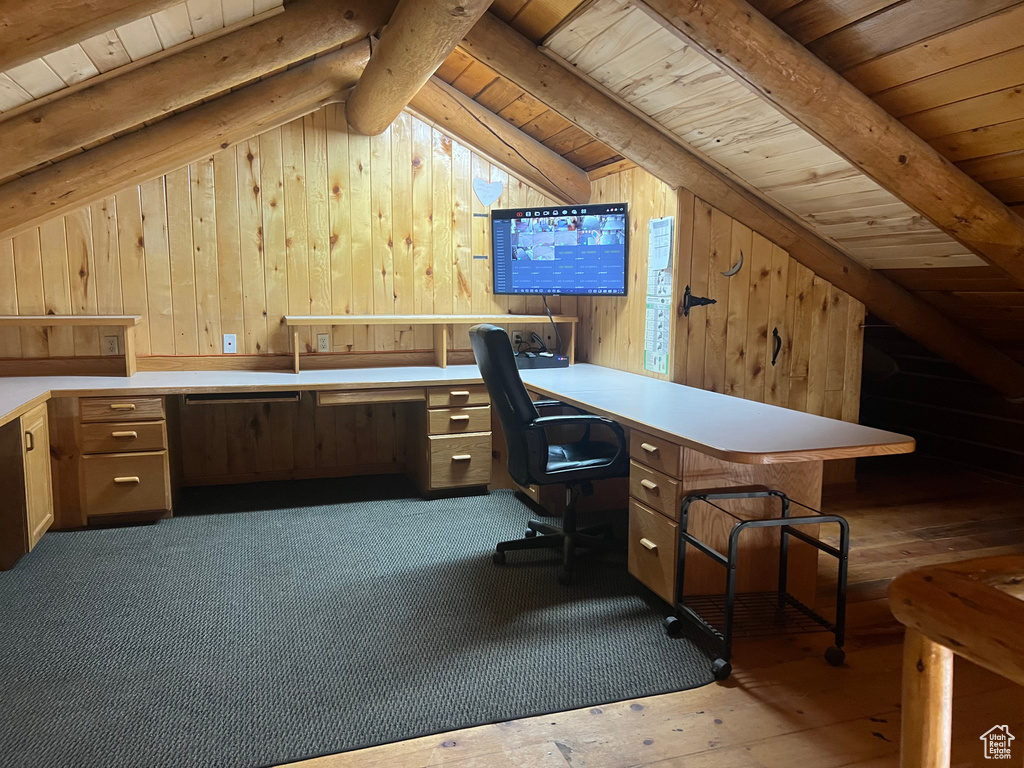 Office space featuring wood ceiling, wooden walls, and built in desk