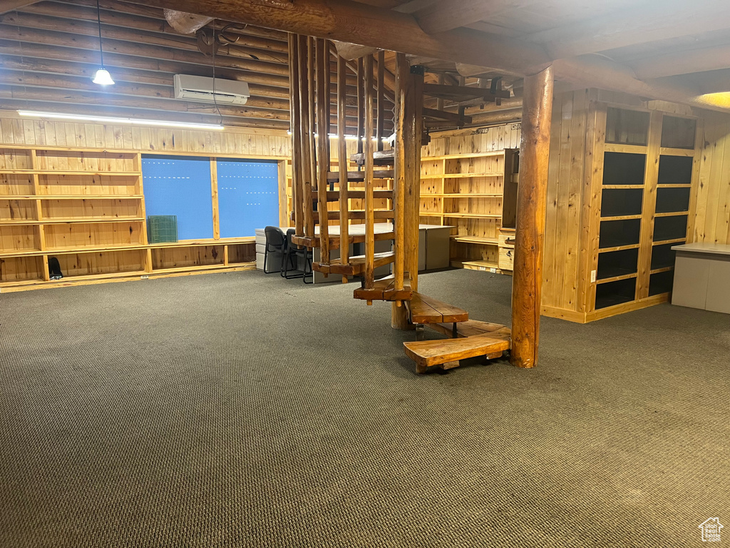 Below grade area with carpet and a wall mounted air conditioner