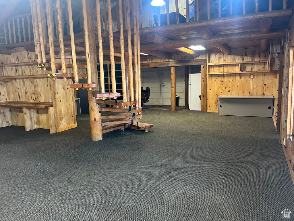 Unfinished below grade area featuring carpet and wooden walls
