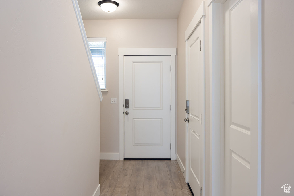 Hall with light wood-style flooring and baseboards