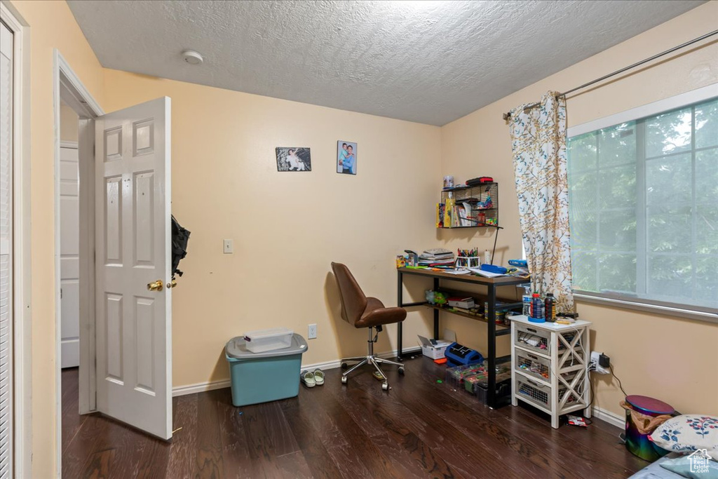 Office space with wood finished floors, baseboards, and a textured ceiling