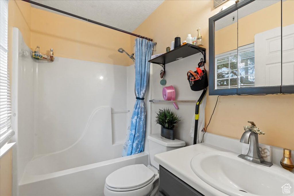 Full bath featuring shower / bathtub combination with curtain, toilet, and vanity