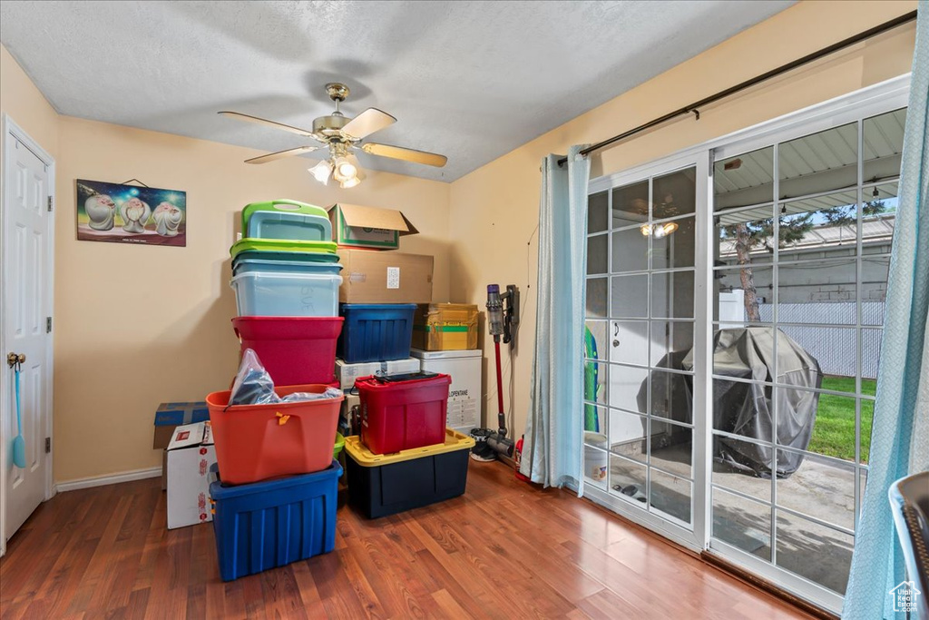 Playroom featuring a ceiling fan, wood finished floors, baseboards, and a textured ceiling