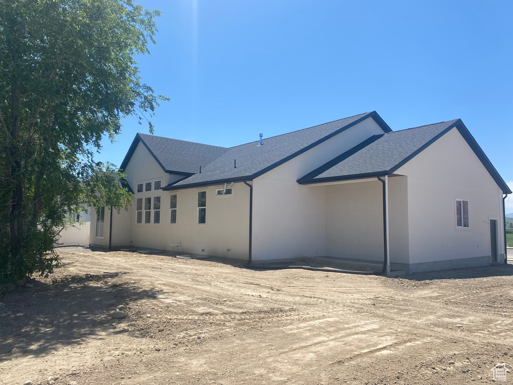 Rear view of property with roof with shingles