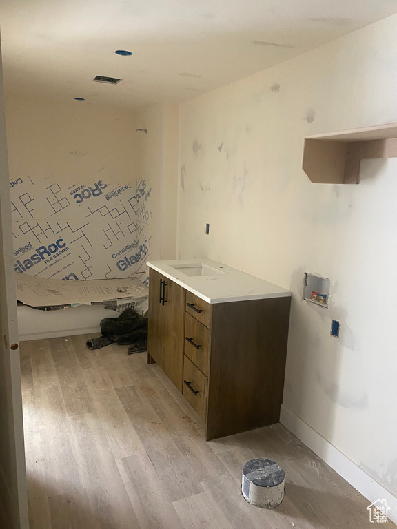 Laundry room featuring light wood-style floors