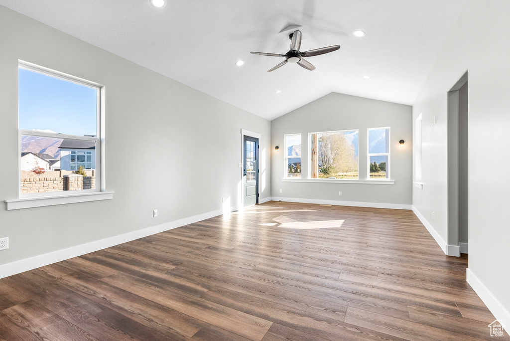 Empty room featuring a ceiling fan, lofted ceiling, wood finished floors, recessed lighting, and baseboards