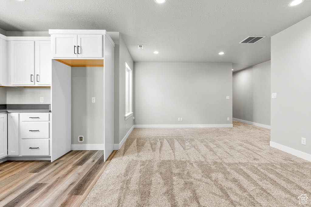 Kitchen with recessed lighting, white cabinets, dark countertops, and baseboards
