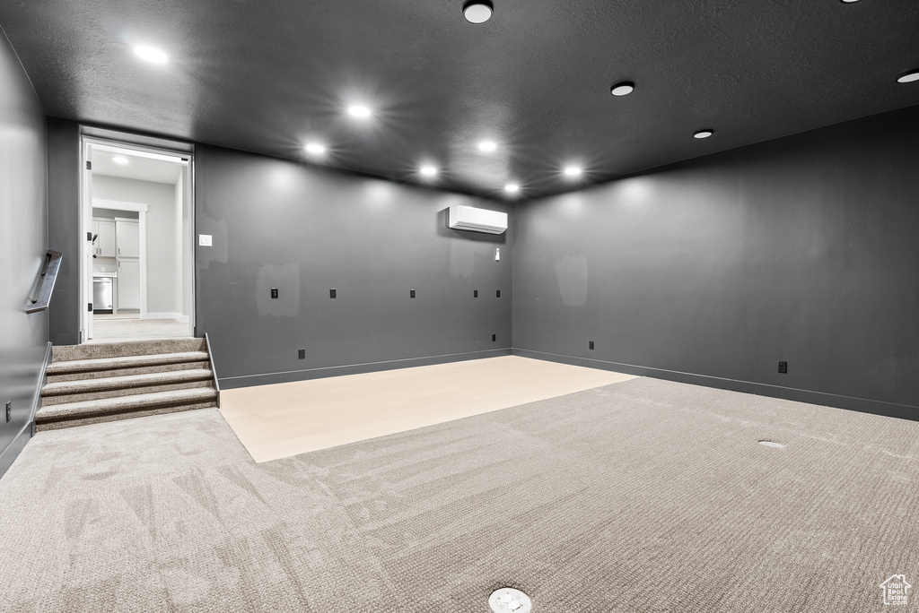 Unfurnished room with a wall unit AC, carpet, recessed lighting, and baseboards