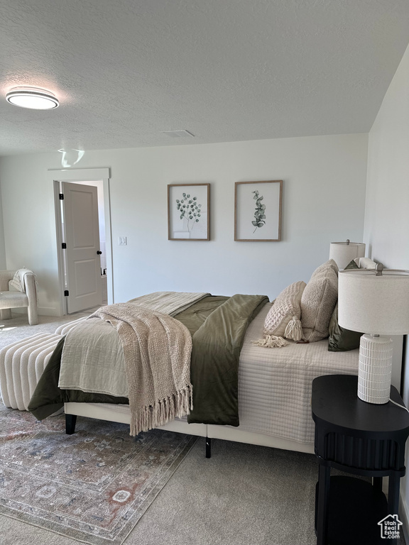 Bedroom featuring a textured ceiling and carpet floors
