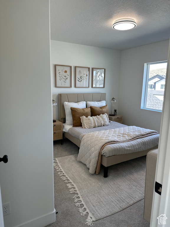 Bedroom with a textured ceiling and carpet floors
