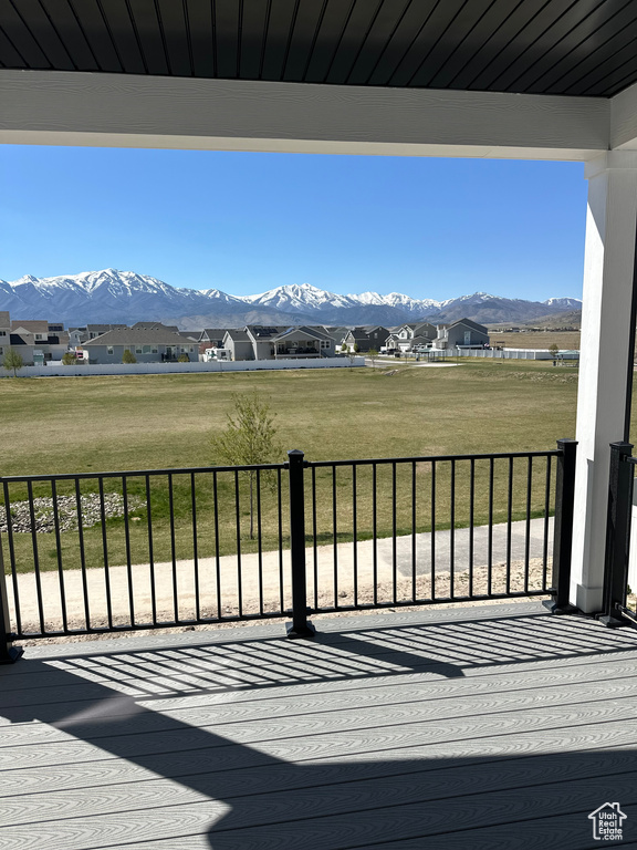 Wooden deck featuring a mountain view, a yard, and a residential view