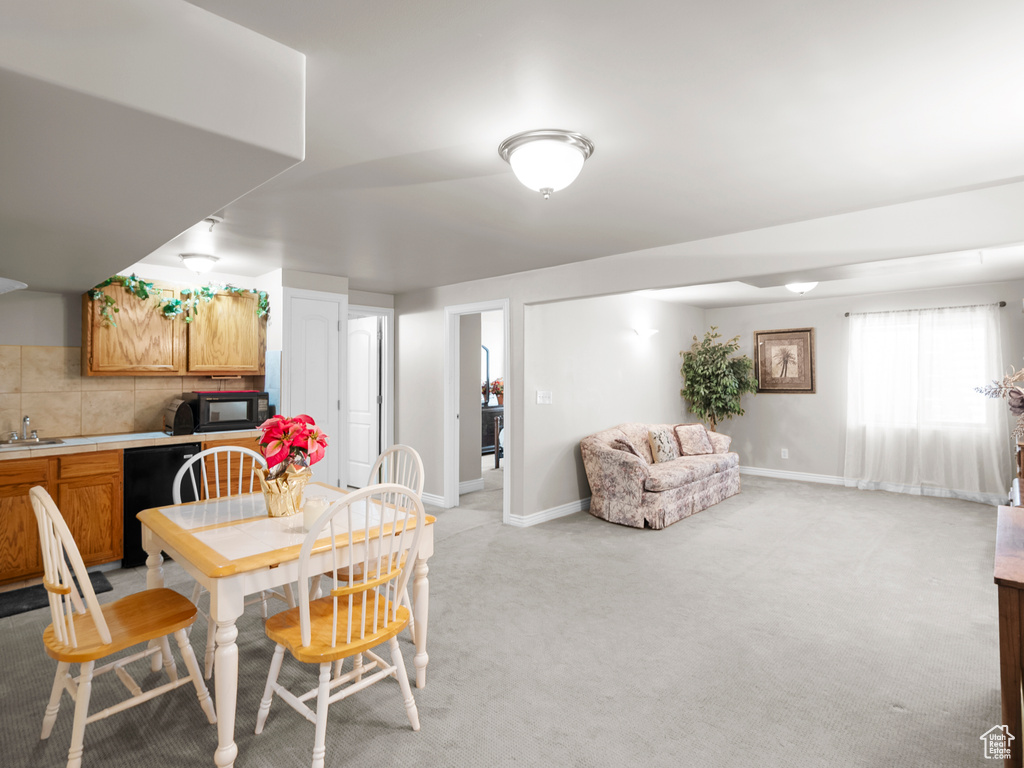 Dining room with baseboards and light colored carpet