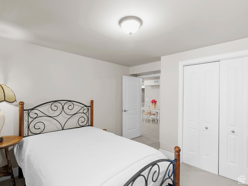 Bedroom featuring light carpet and a closet