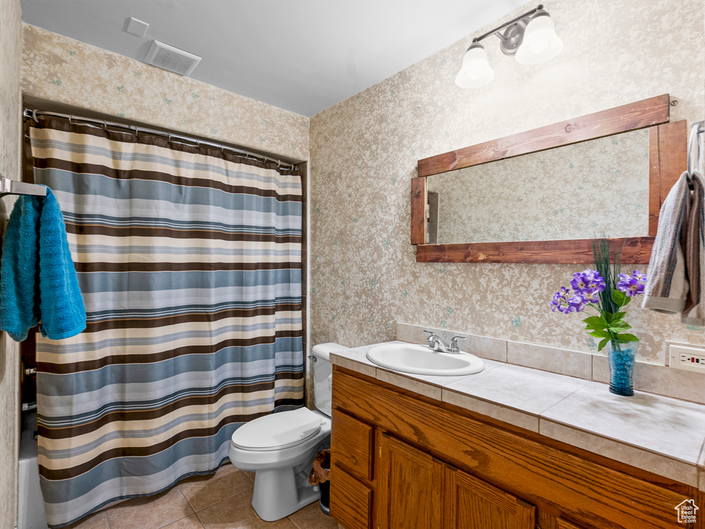 Bathroom with vanity, toilet, tile patterned floors, wallpapered walls, and a shower with curtain