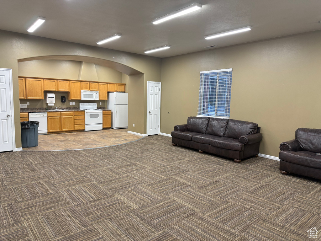 Living area featuring dark carpet and baseboards
