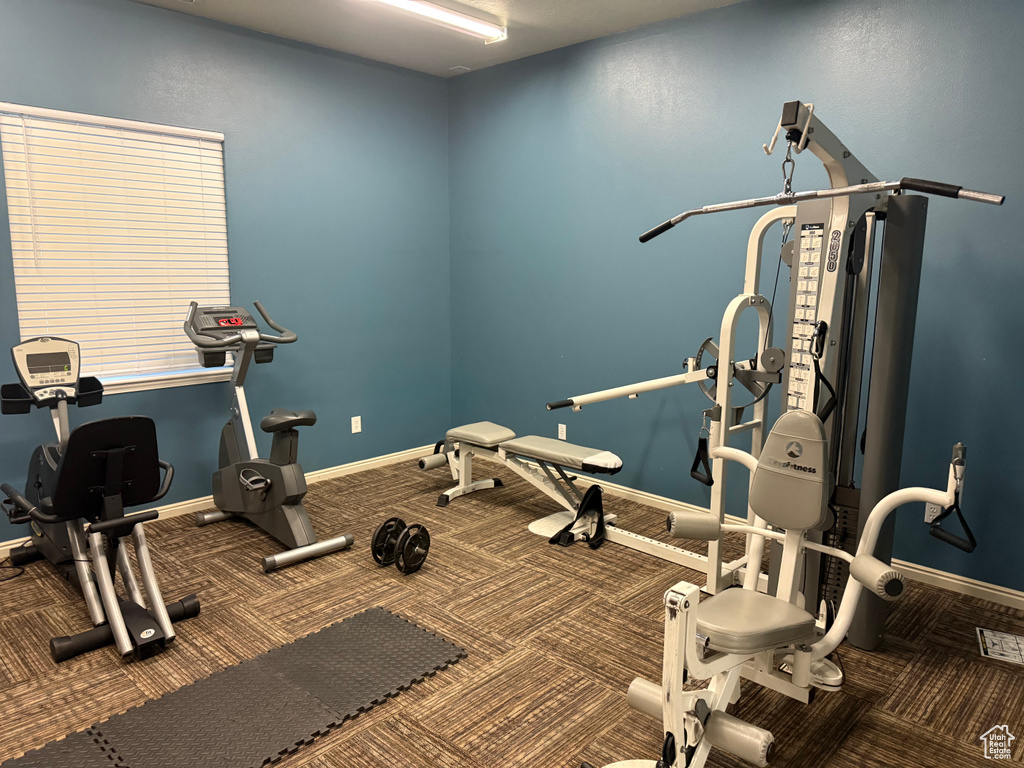 Exercise room featuring carpet and baseboards