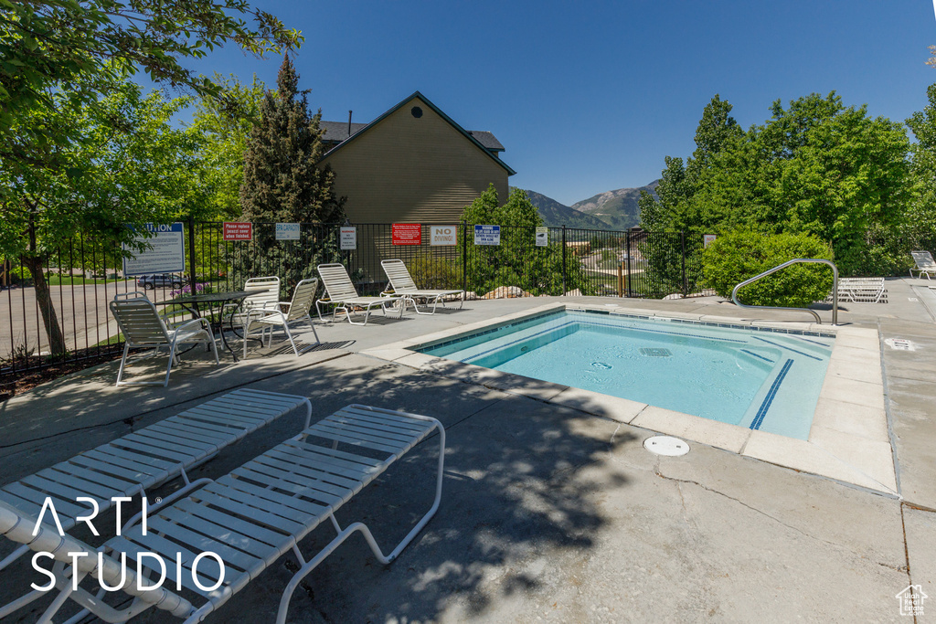 View of swimming pool with a mountain view, a patio area, and a pool