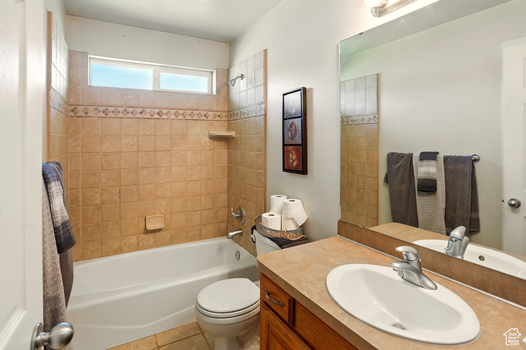 Bathroom featuring vanity, bathtub / shower combination, toilet, and tile patterned flooring