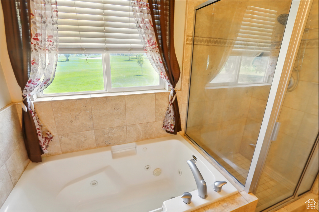 Full bath with a shower stall and a whirlpool tub